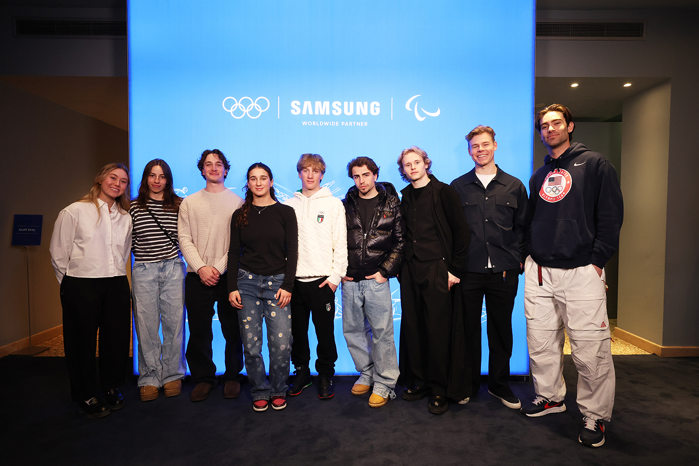 Team Samsung Galaxy athletes pose in front of a large screen at Samsung House during the Hwaiting Night event.